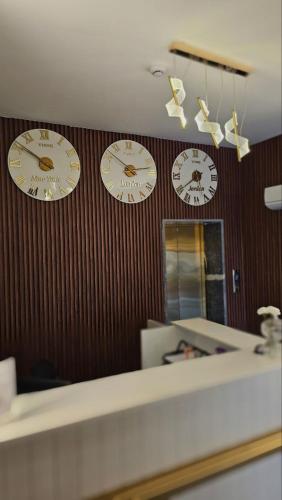 three clocks hanging on a wall in a room at VIP Hotel Amman in Amman