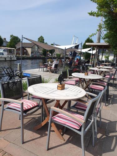a row of tables and chairs sitting next to a river at Hotel Noudus in Delfstrahuizen