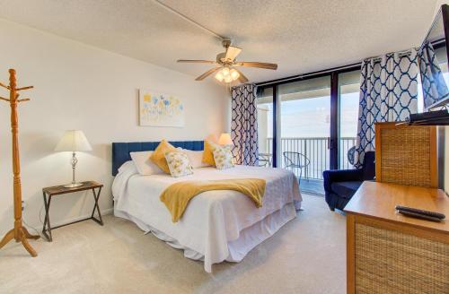 a bedroom with a bed and a balcony at Pelican Watch in Carolina Beach