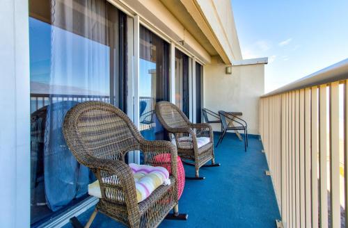 two chairs sitting on a balcony with windows at Pelican Watch in Carolina Beach
