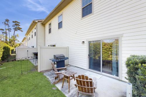 a backyard with a grill and two chairs at St Simons Serenity in Jewtown