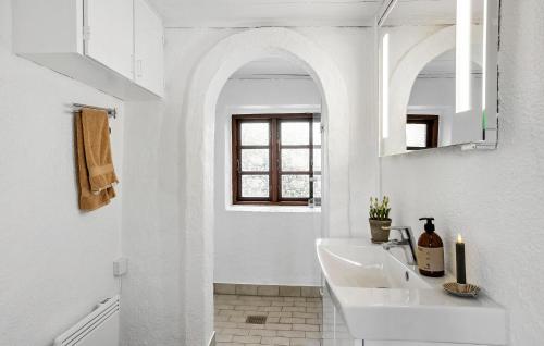 a white bathroom with a sink and a window at 4 Bedroom Awesome Home In Rudkøbing in Rudkøbing