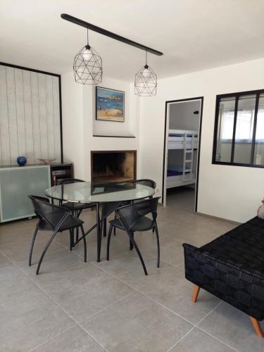 une salle à manger avec une table et des chaises en verre dans l'établissement Les Callunes, à Guidel