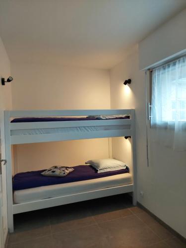 une chambre avec deux lits superposés dans une pièce dans l'établissement Les Callunes, à Guidel