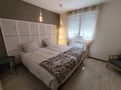 une chambre avec un lit et une grande fenêtre dans l'établissement Le 604, confort et détente, à Fort-Mahon-Plage