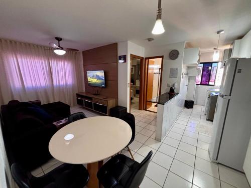 a living room with a table and a kitchen at Apartamentos Renovatio Jatiuca - Castelo B Temporada in Maceió
