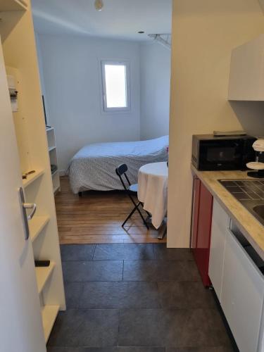 - une cuisine avec un lit et une table dans une chambre dans l'établissement Bohemian cosy flat, à Paris