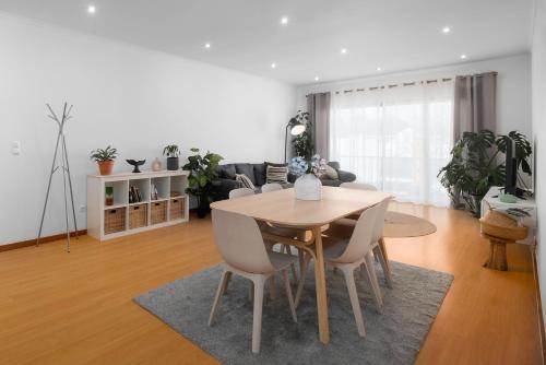 a living room with a wooden table and chairs at Paim Apartments in Ponta Delgada