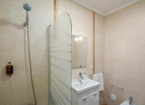 a bathroom with a sink and a mirror at Paim Apartments in Ponta Delgada