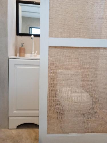 a bathroom with a toilet and a sink at Casa Ha Hostal in Mérida