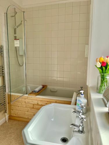 a bathroom with a sink and a shower with a tub at High Street Haven nr Blenheim Palace in Woodstock