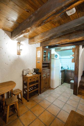 a kitchen with a table and a refrigerator at Alojamento Casas da Serra in Porto Santo