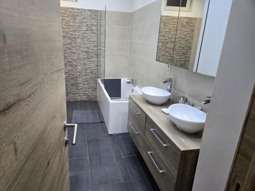 a bathroom with two sinks and a mirror at Yaël House in Brussels