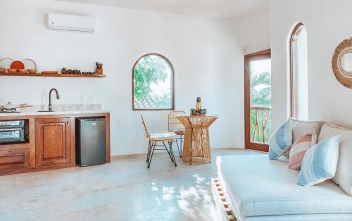 a living room with a couch and a kitchen at Amari Sayulita Boutique Hotel in Sayulita