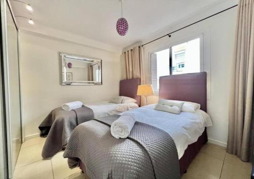 une chambre avec deux lits et un miroir dans l'établissement Appartement de deux chambres à coucher près de la Croisette à Cannes, à Cannes