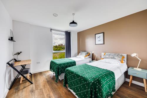 a bedroom with two beds and a window at Penthouse Apartment - City Centre - Secure Parking, Balcony, Self-Check-In, Fast Wifi and Smart TV with Netflix by Yoko Property in Milton Keynes
