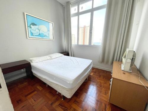 une petite chambre avec un lit et une fenêtre dans l'établissement Apê Vista Mar - 50m da Praia Pitangueiras, à Guarujá