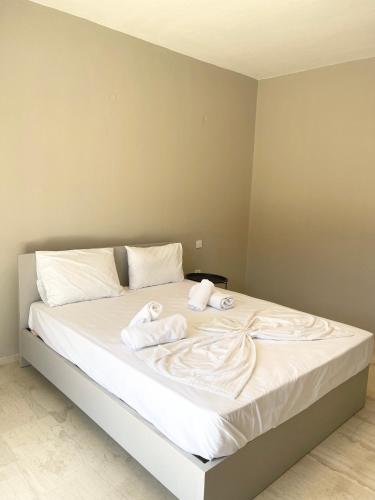 una camera da letto con un letto con asciugamani sopra di Fairytale Apartments a Plataria
