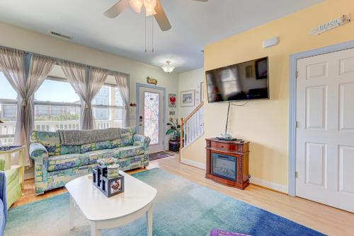 Una sala de estar con un sofá y un televisor. en Poopka & Dennys Beach Condo by Carolina Beach Realty, en Carolina Beach