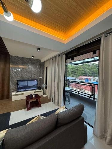 a living room with a couch and a television at Yanna's Unit - 3Bedroom with Breakfast in Baguio