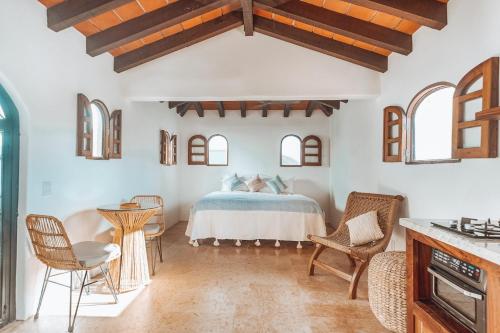 a bedroom with a bed and chairs in a room at Amari Sayulita Boutique Hotel in Sayulita