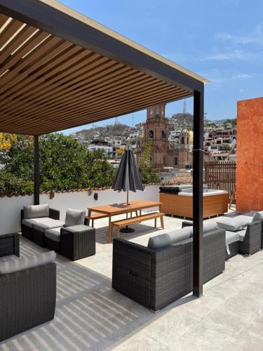 a patio with couches and a table on a roof at Hotel Casa Kavia Vallarta in Puerto Vallarta