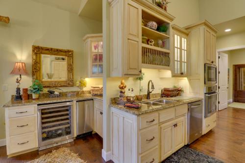 a kitchen with white cabinets and a sink and a mirror at Riverfront Mountain Home quarter Mi to Boat Launch in Norfork