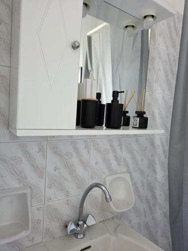 a bathroom with a sink and a shelf with a mirror at Calypso Heaven in Santorini