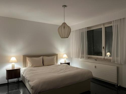 a bedroom with a bed with two lamps and a window at Cozy Central Apartment in Basel