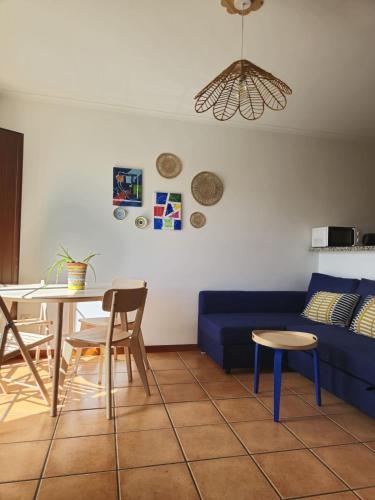 a living room with a blue couch and a table at Alqueva Beach House in Mourão