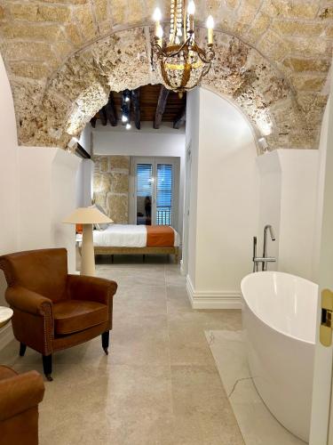 a bathroom with a tub and a bedroom with a bed at Addimura rooms in Palermo