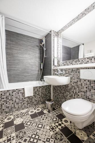 une salle de bain avec toilettes et lavabo dans l'établissement Kyriad Valenciennes Sud - Rouvignies, à Valenciennes