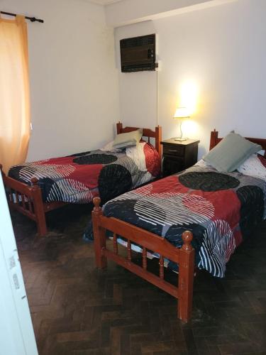a room with two beds in a room at Casa Al pie del Cerro in Yerba Buena