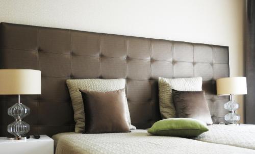 a bed with two lamps and a green pillow on it at Milfontes Guest House - Duna Parque Resorts & Hotels in Vila Nova de Milfontes