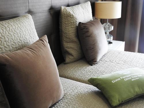 a bed with two pillows on top of it at Milfontes Guest House - Duna Parque Resorts & Hotels in Vila Nova de Milfontes