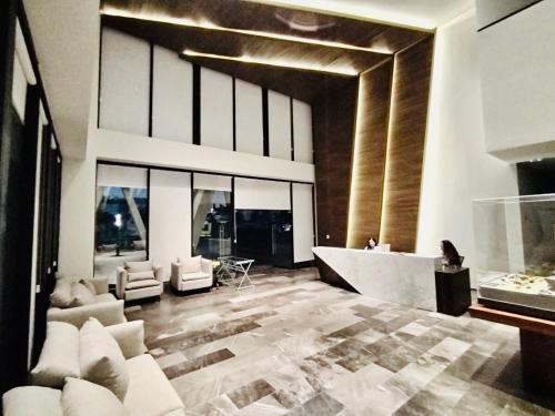 a living room with white furniture and a large window at New apartment in the heart of GDL in Guadalajara