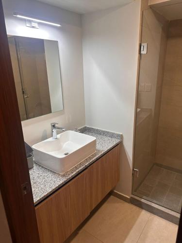 a bathroom with a white sink and a mirror at New apartment in the heart of GDL in Guadalajara