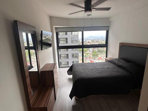 a bedroom with a bed and a large window at New apartment in the heart of GDL in Guadalajara