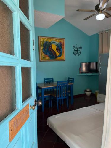 a room with a bed and a table and a ceiling fan at PLAYA BLANCA BED AND BREAKFAST in Bayahibe