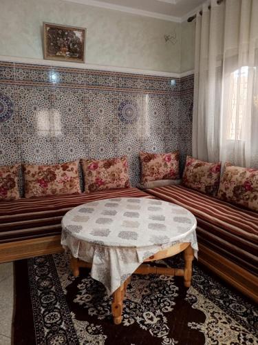 a living room with a couch and a table at Appartement in Benguerir