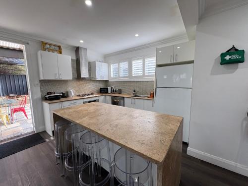 a kitchen with white cabinets and a large island at Rest on Keppel in Bathurst