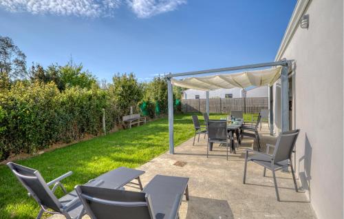 un patio con sillas y una mesa bajo un dosel en Stunning Home In La Brée-Les-Bains, en La Brée-les-Bains
