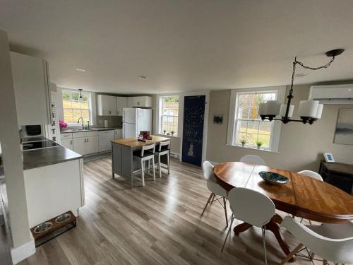 a kitchen and dining room with a table and chairs at Cozy Harbour House in Isaacs Harbour
