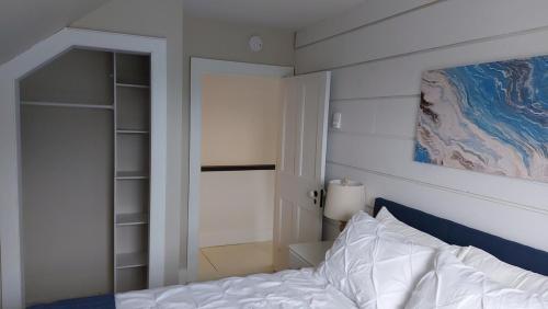 a bedroom with a bed and a painting on the wall at Cozy Harbour House in Isaacs Harbour