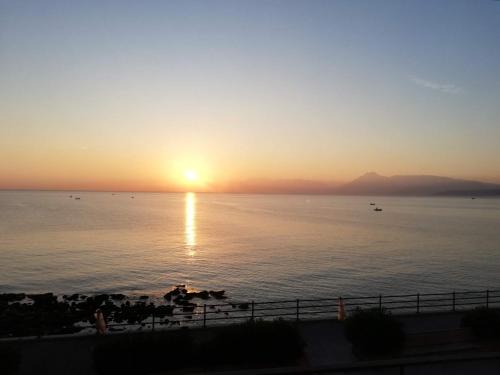a sunset over a body of water with the sun setting at Case Nereidi 2 in Porticello