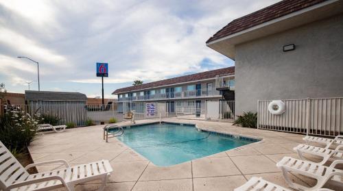 a swimming pool with chairs and a hotel at Motel 6 Ontario, CA - Airport in Ontario