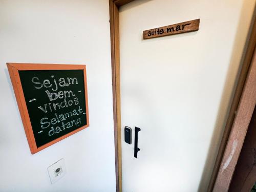 a chalkboard on a door with a sign on it at Quintal do Contêiner em Manguinhos in Manguinhos