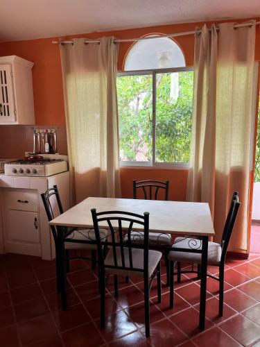 a kitchen with a table and chairs and a window at PLAYA BLANCA BED AND BREAKFAST in Bayahibe