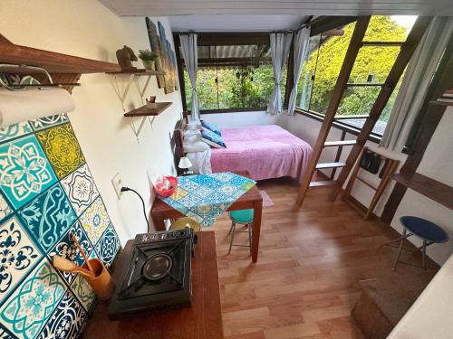a bedroom with a bed and a stove in a room at Quintal do Contêiner em Manguinhos in Manguinhos