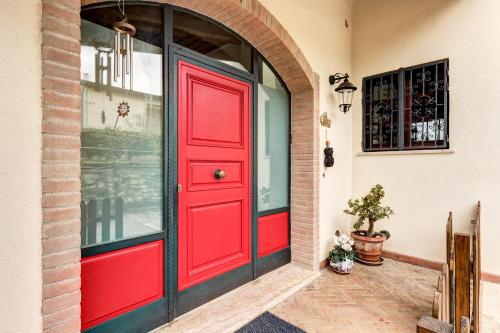 a red door on a building with a window at Back Home in Pienza